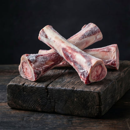 Three raw bones on a wooden board with smoke rising against a dark background