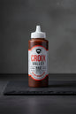 Bottle of Croix Valley BBQ Sauce with a white cap on a black background