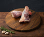 Raw lamb on a wooden cutting board with text about premium lamb.