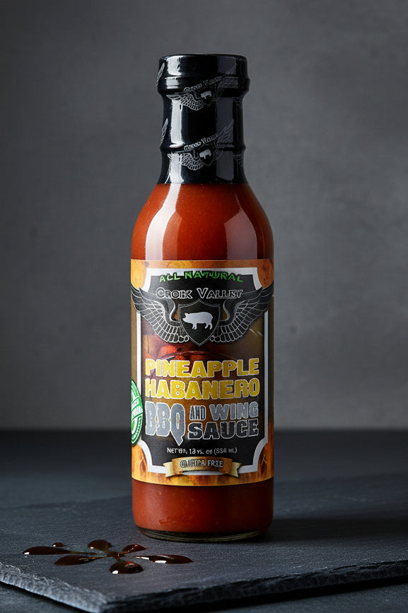 Bottle of Pineapple Habanero BBQ Sauce with a black cap on a white background