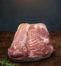 Raw pork belly on a wooden surface with a dark background