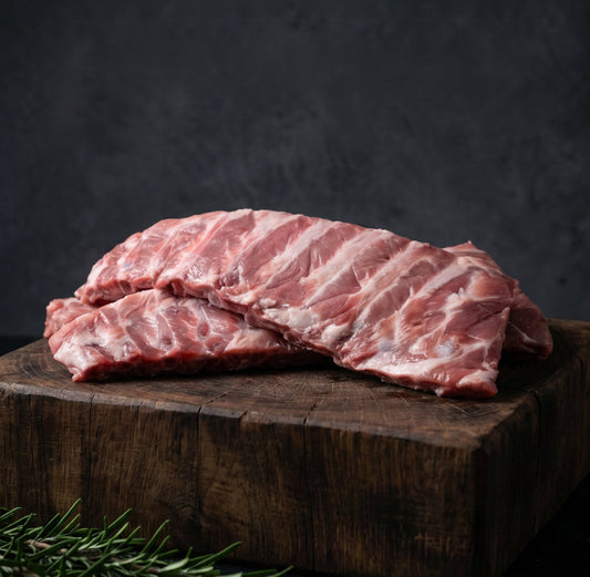 Raw ribs on a wooden cutting board with text about prime cuts and flavor.